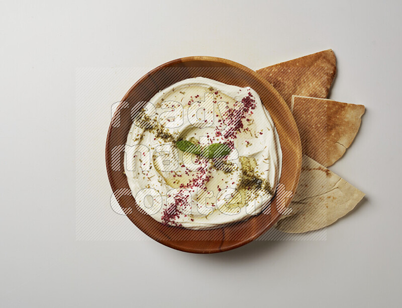 Lebnah garnished with  zattar , sumak & mint in a wooden plate on a white background