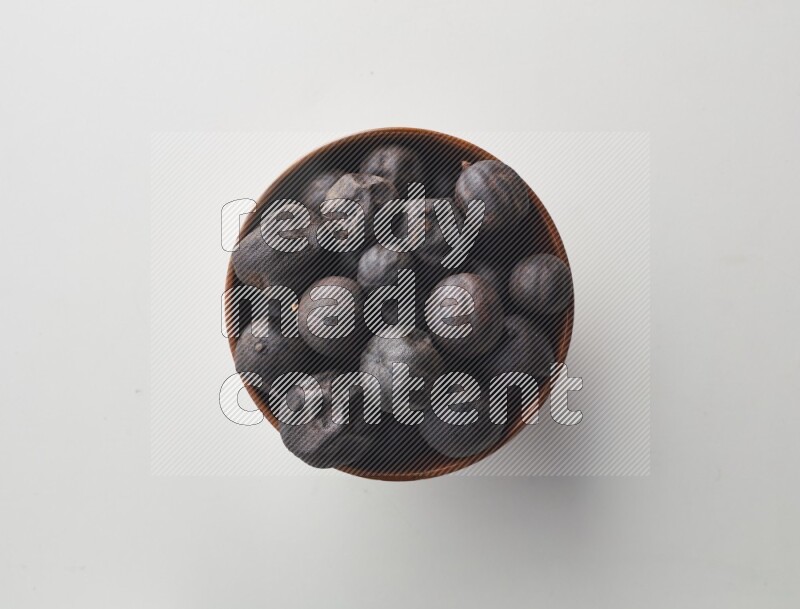 Top-view shot of dried lime (loomi) in a container on white background
