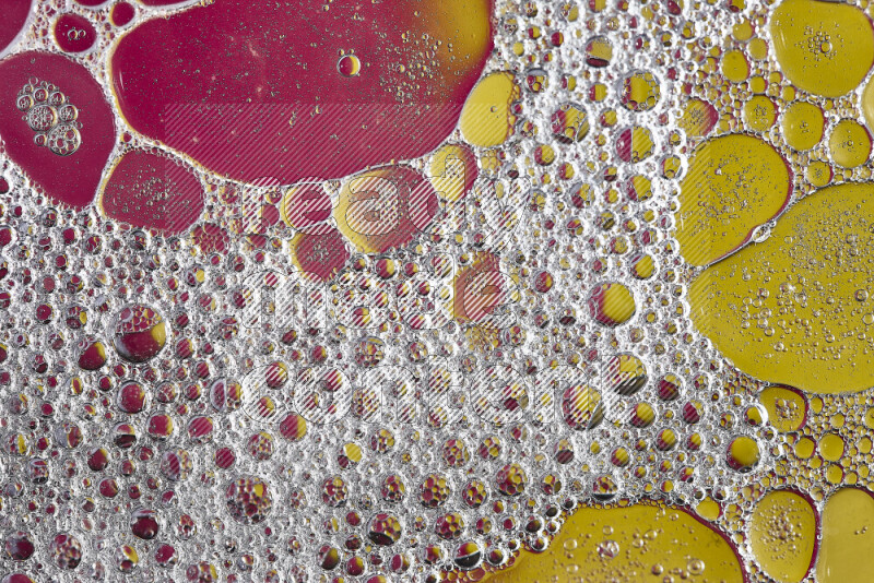 Close-ups of abstract soap bubbles and water droplets on pink and yellow background