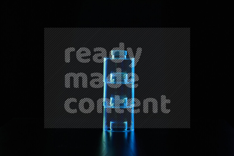 Glassware with rim light in blue and green against black background