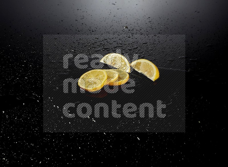 Lemon slices with water drops, and droplets on black background