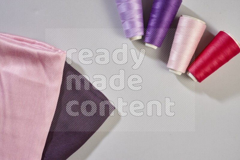 أقمشة متعددة الألوان مع لوازم الخياطة على خلفية رمادية