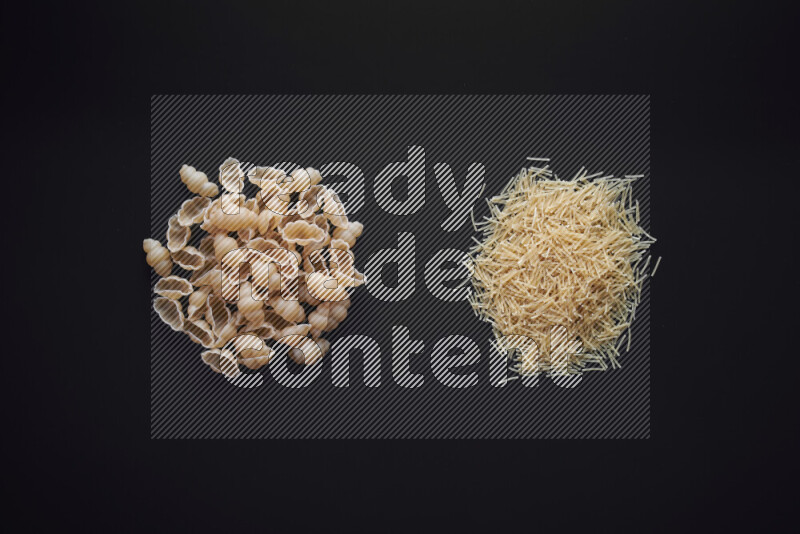 Different pasta types in bunches on black background