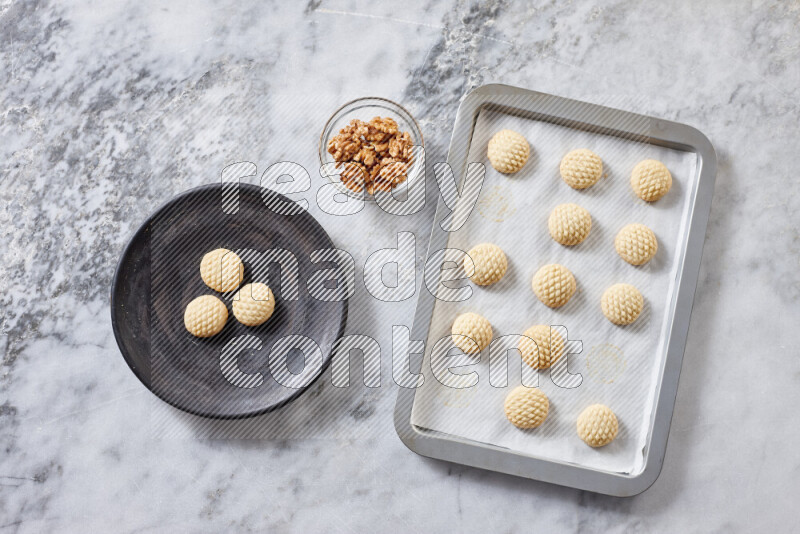Kahk step by step with its ingredients ghee, sugar, flour, sesame, yeast, water and kahk flavor on grey marble background
