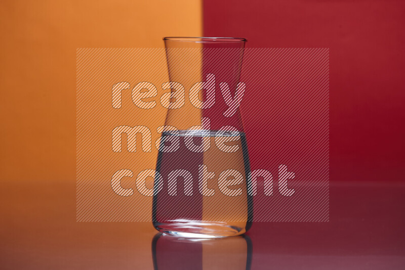 The image features a clear glassware filled with water, set against orange and red background