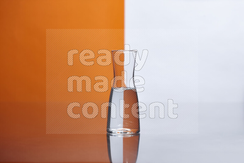 The image features a clear glassware filled with water, set against white and orange background