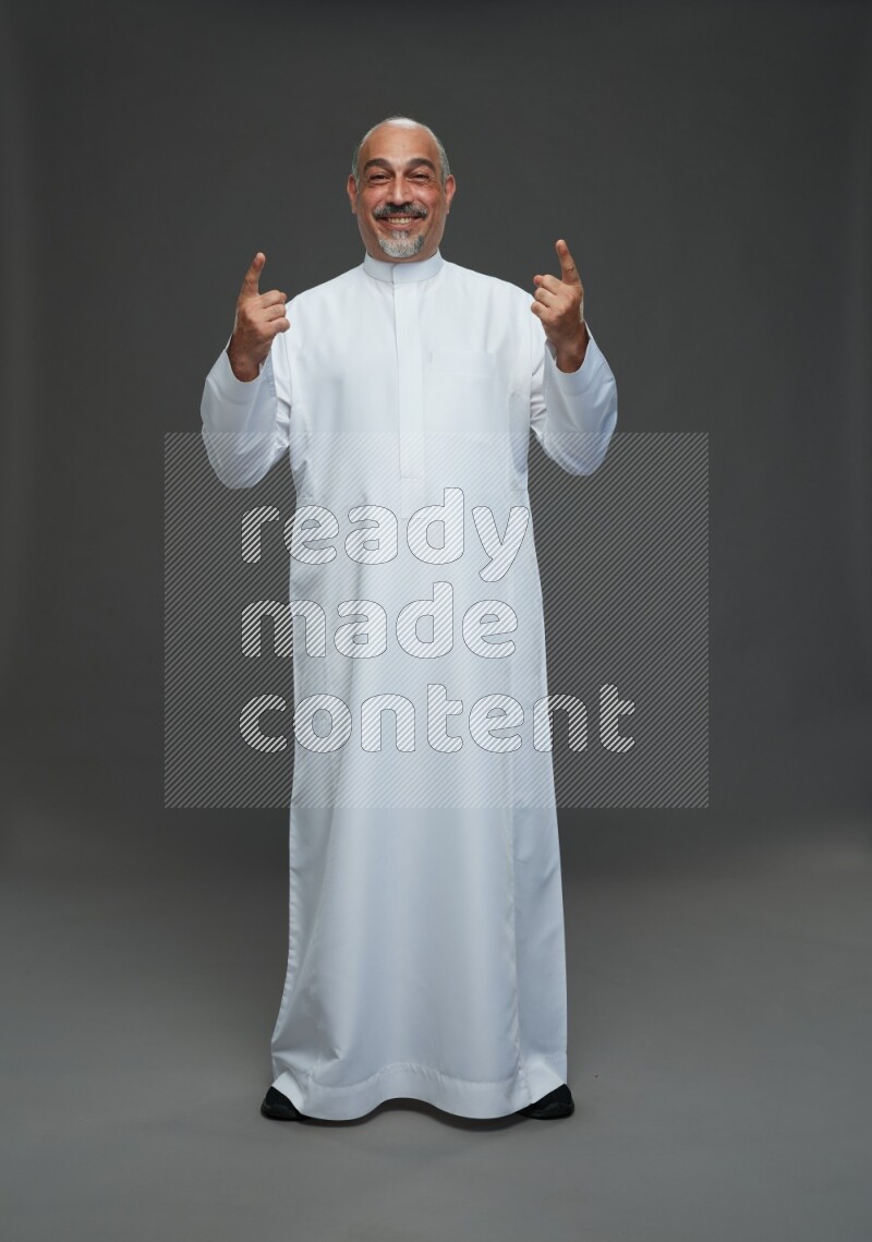 Saudi man without shomag Standing Interacting with the camera on gray background