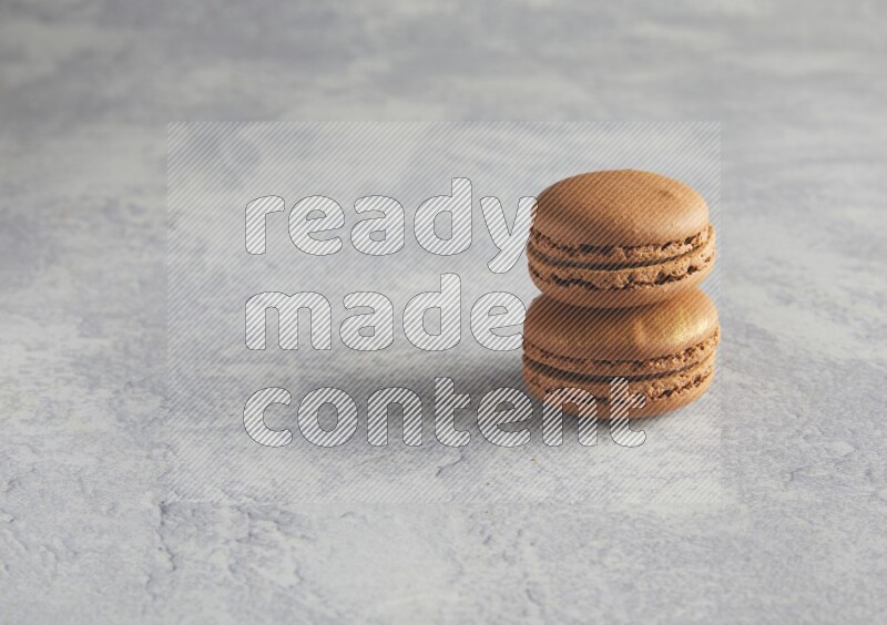 45º Shot of two Brown Coffee macarons  on white  marble background