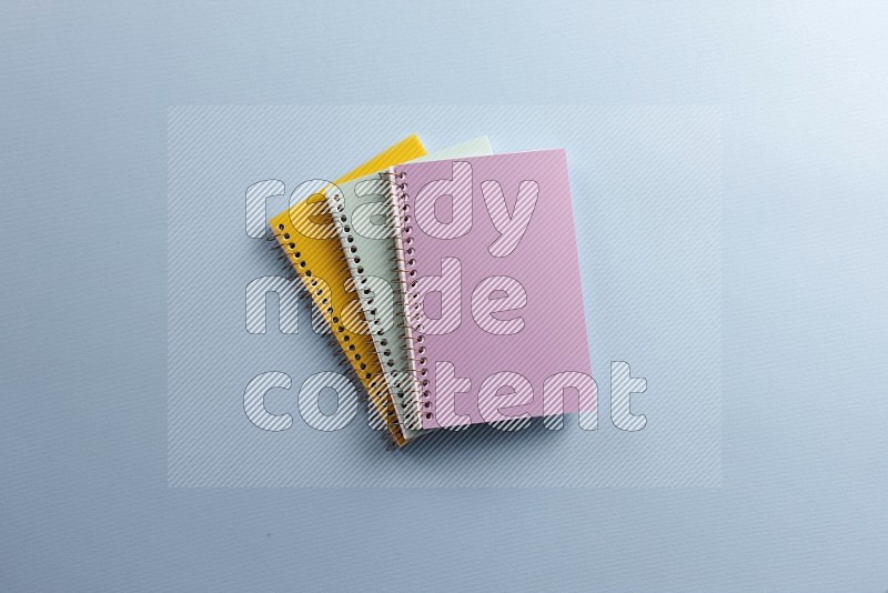 A multicolored notebooks on blue background (Back to school)