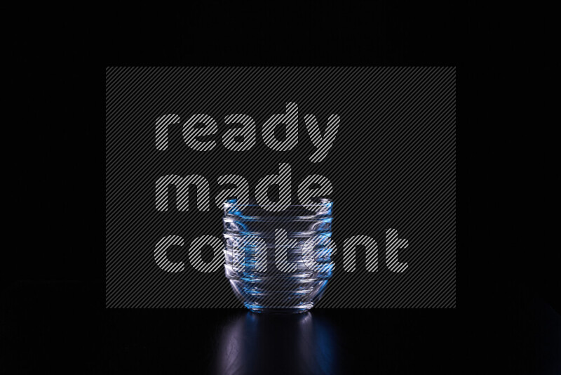 Glassware with rim light in blue and white against black background