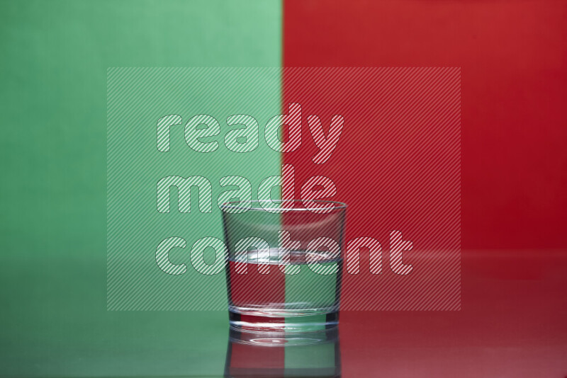 The image features a clear glassware filled with water, set against green and red background