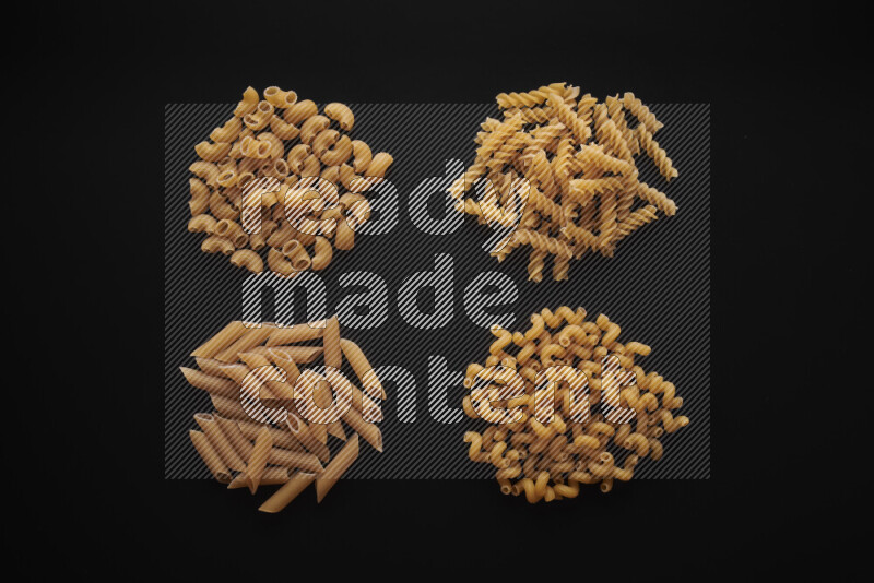 Different pasta types in bunches on black background