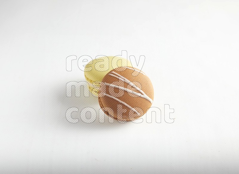 45º Shot of of two assorted Brown Irish Cream, and Yellow Lime macarons on white background