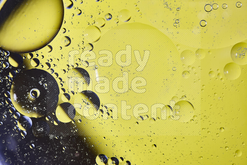 Close-ups of abstract oil bubbles on water surface in shades of black and yellow