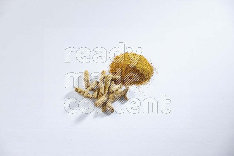 بودرة الكركم وأصابع الكركم المجففة على خلفية بيضاء