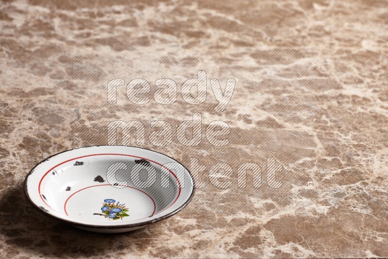 صحن معدني عتيق على خلفية رخام بيج