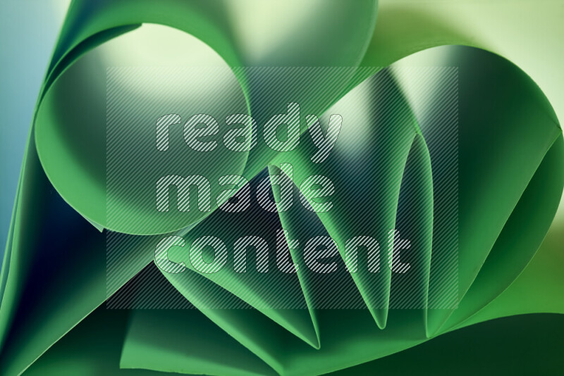 عرض فني لطيات الورق تخلق مزيج من الأشكال الهندسية، مضاءة بإضاءة ناعمة بدرجات اللون الأخضر