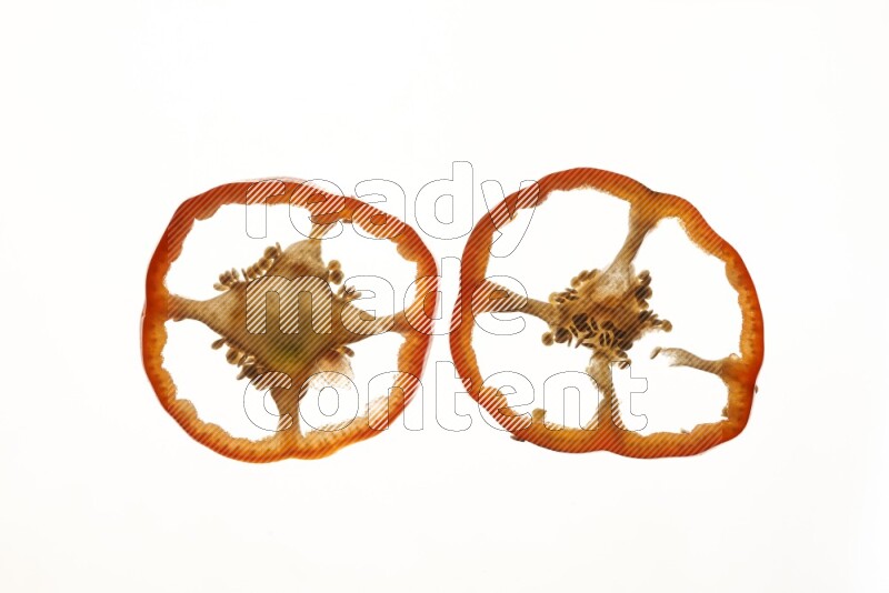 Red bell pepper slices on illuminated white background