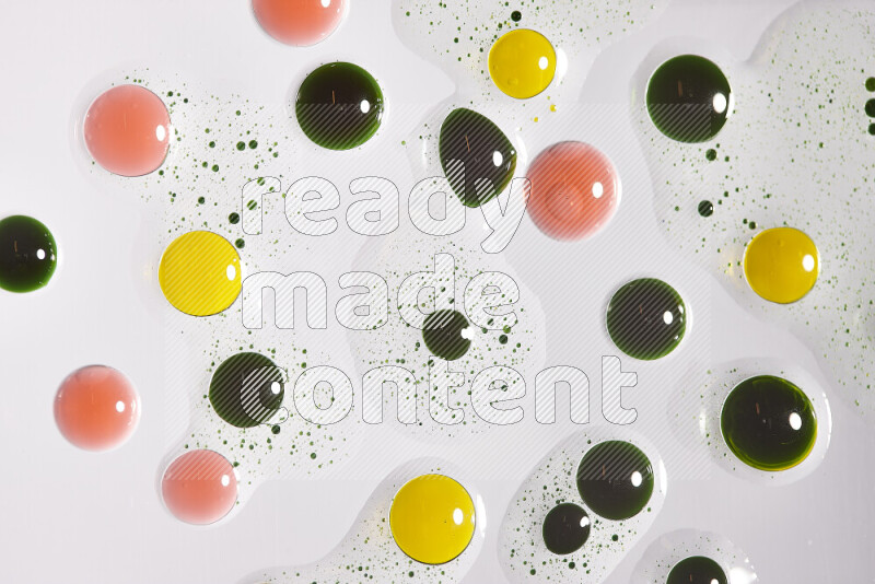 Close-ups of abstract green, yellow and red paint droplets on the surface