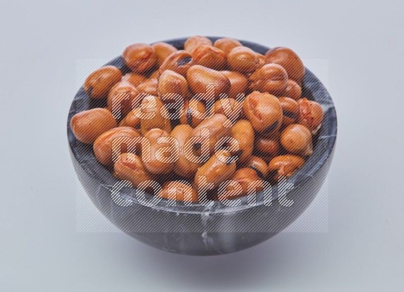 Close up shot of cooked fava beans (foul) in a container on white background