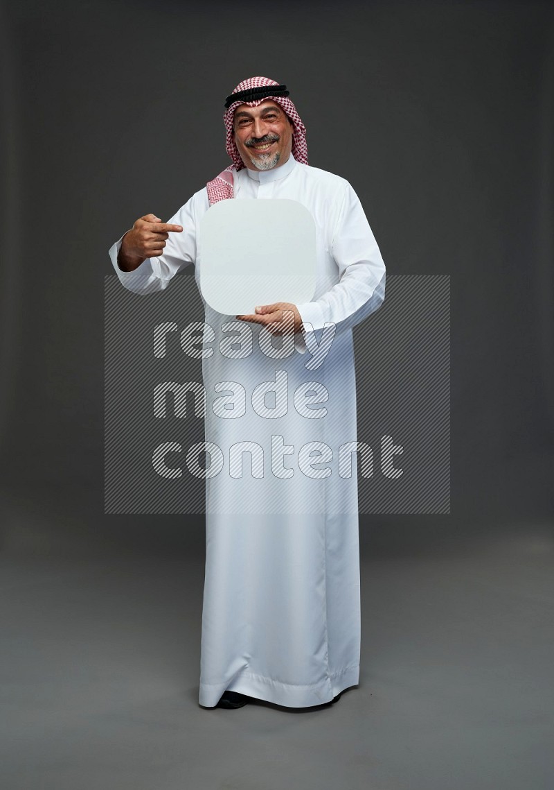 Saudi man with shomag Standing holding social media sing on gray background