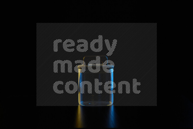 Glassware with rim light in blue and yellow against black background