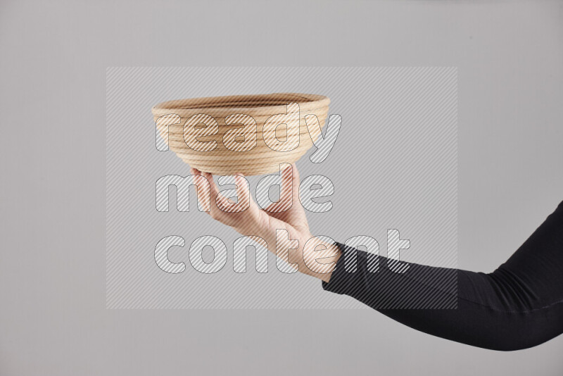 امرأة ترتدي عباءة سوداء تحمل أدوات خشبية مختلفة في أوضاع متعددة