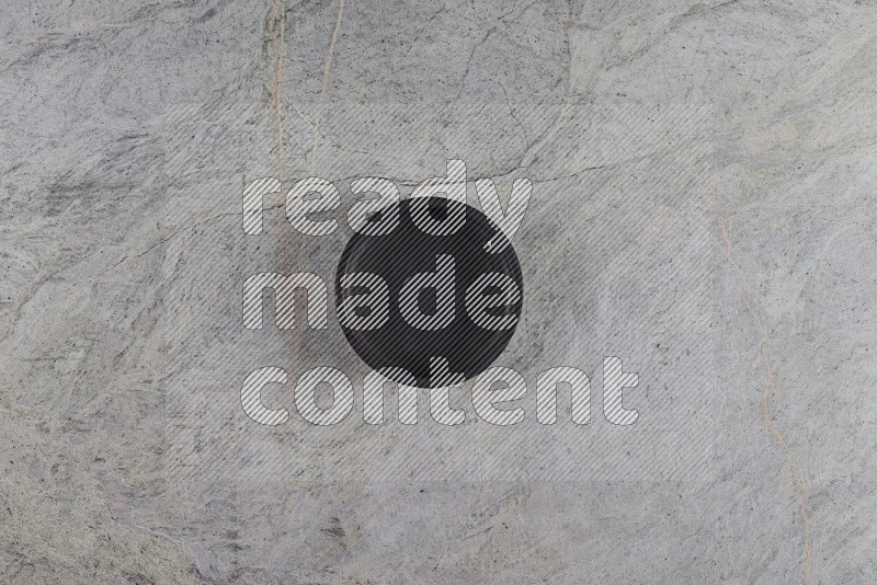 Top View Shot Of A Black Pottery Bowl On Grey Marble Flooring