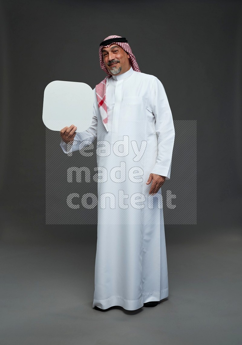 Saudi man with shomag Standing holding social media sing on gray background