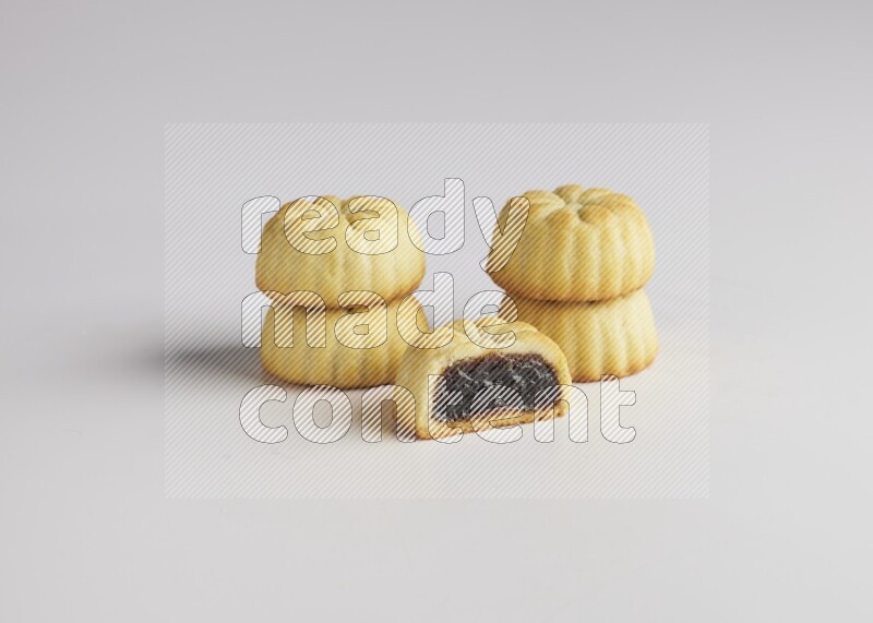 Five Pieces of Maamoul filled with date one of them is cut direct on white background