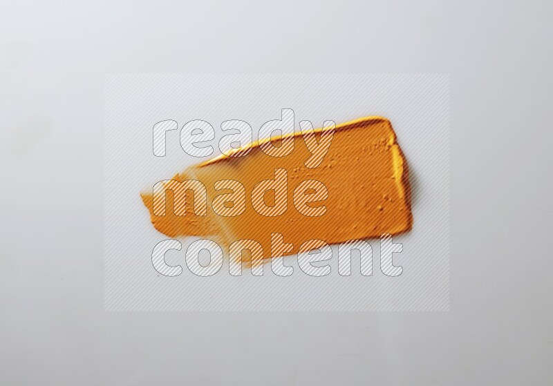 An orange straight painting knife stroke on white background