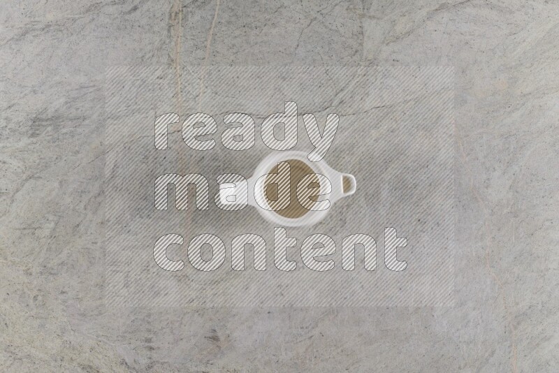 A ceramic milk jug on grey marble background