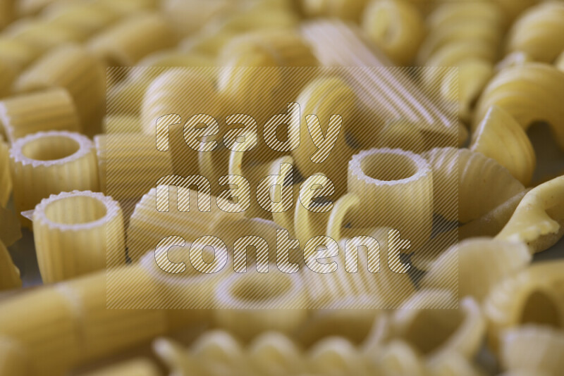 Different pasta types on light blue background