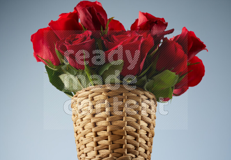 Vibrant red roses in a wicker basket on black marble background