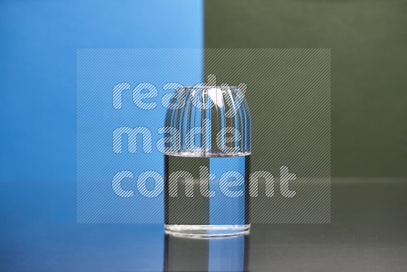 The image features a clear glassware filled with water, set against blue and dark green background