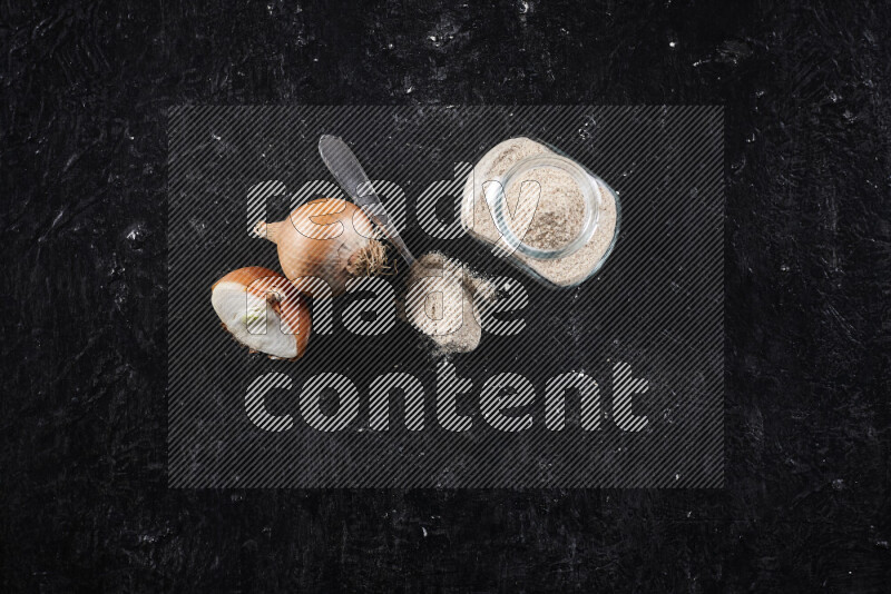 وعاء زجاجي ممتلئ ببودرة البصل علي خلفية سوداء