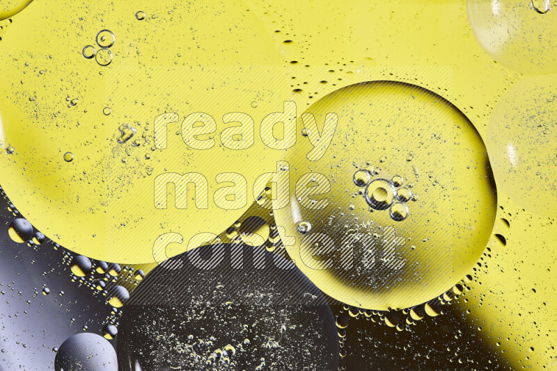 Close-ups of abstract oil bubbles on water surface in shades of black and yellow