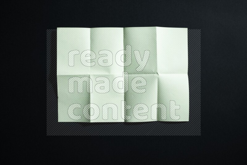 Green paper sheet on black background