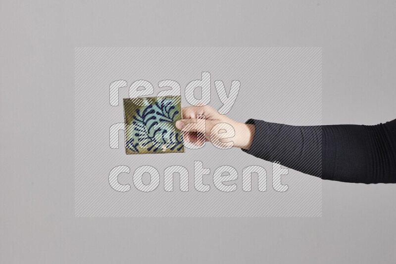 A woman in black abaya holding different pottery essentials in different positions