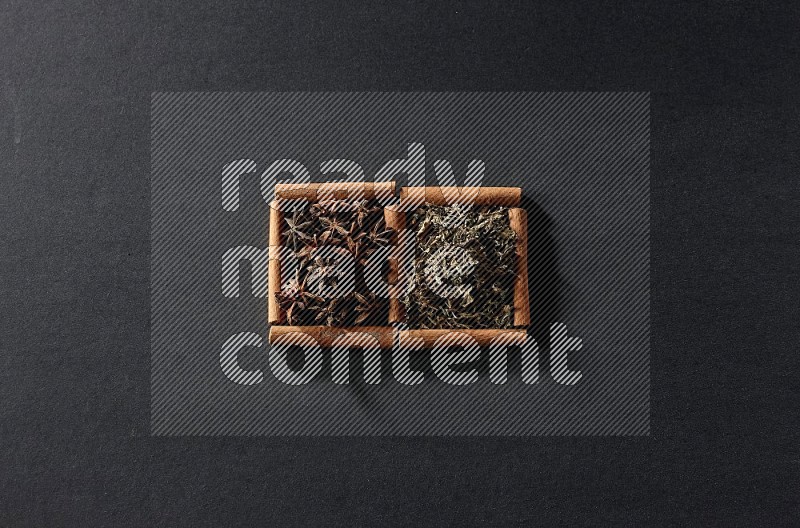 2 squares of cinnamon sticks full of star anise and dried basil on black flooring