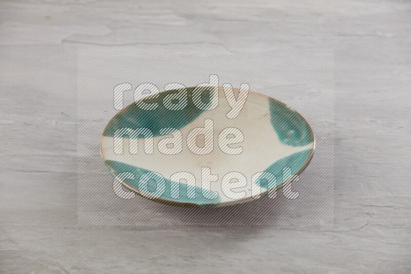 multi color ceramic round plate on grey textured countertop