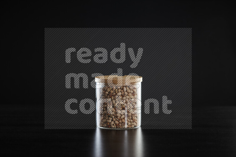 Black-eyed peas in a glass jar on black background