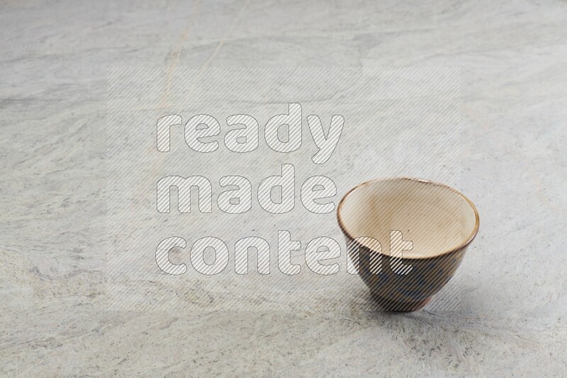 A multicolored pottery bowl on grey marble background