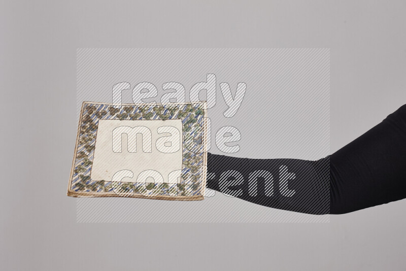 A woman in black abaya holding different pottery essentials in different positions