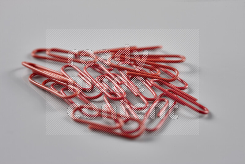Red paper clips isolated on a grey background