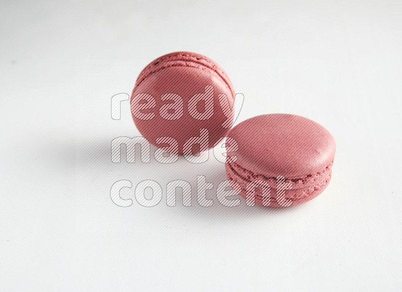 45º Shot of two Pink Raspberry macarons on white background