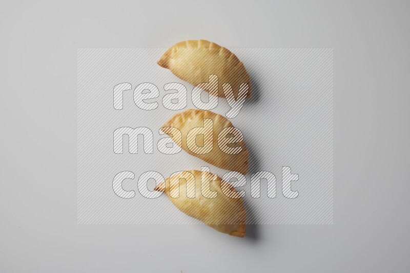 Three fried sambosa from a top angle on a white background