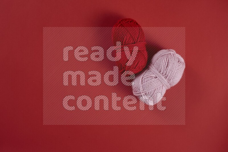 مجموعة من أدوات الخياطة والتفصيل زهرية وحمراء اللون على خلفية حمراء