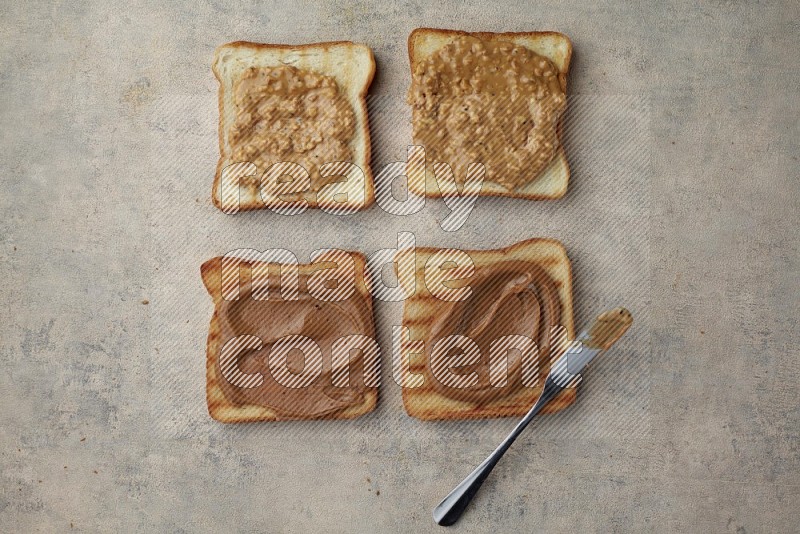 Creamy and crunchy peanut butter on a toasted white toast slices on a light blue textured background