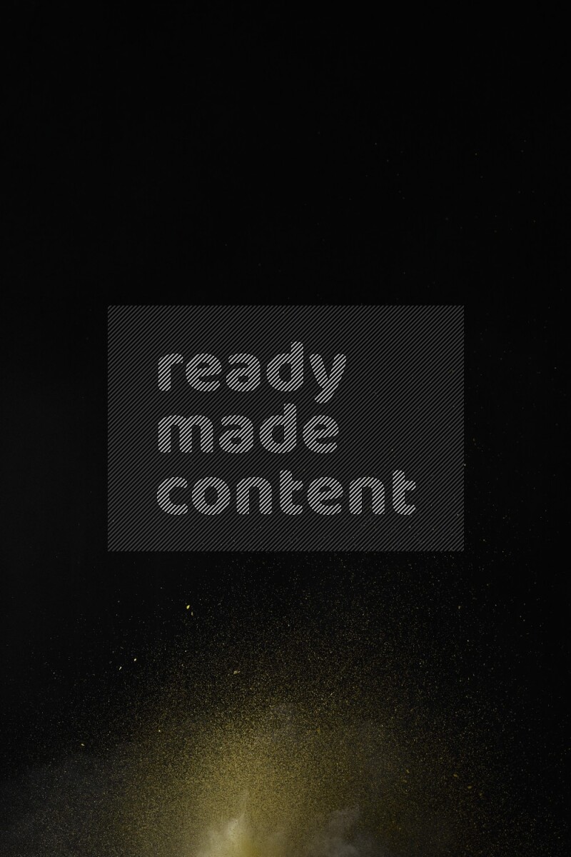 A side view of yellow powder explosion on black background